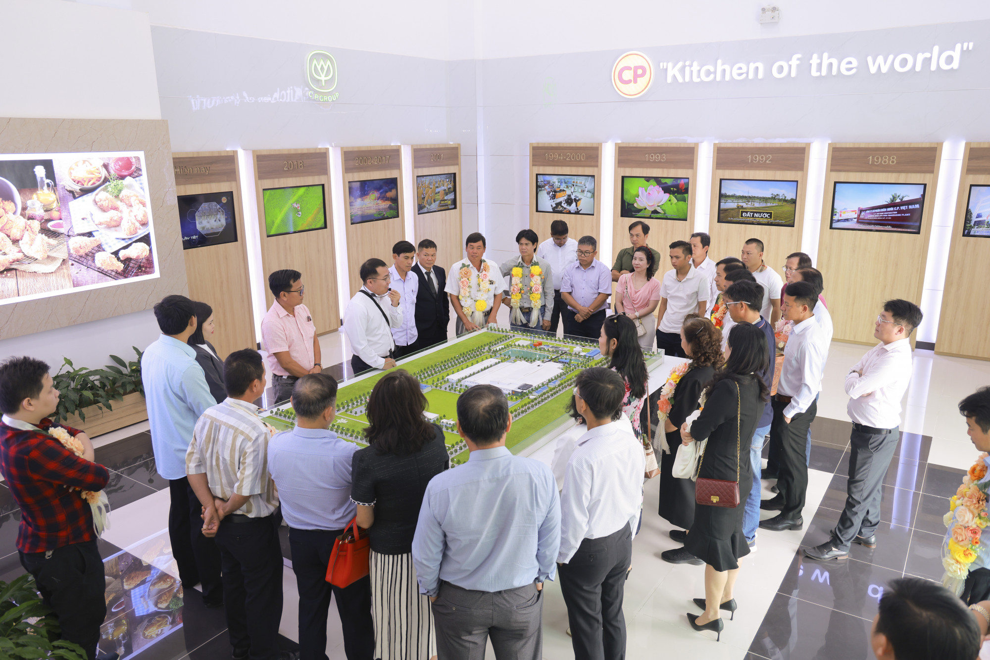 Các chủ trang trại gia công tham quan mô hình trưng bày sơ đồ tổng thể nhà máy CPV Food Bình Phước - Ảnh: H.Q