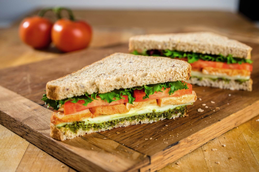 Sandwich bơ – cà chua – rau mầm tưởng chừng đơn giản nhưng lại là công thức “nhỏ mà có võ” dành cho người ăn uống có ý thức. Phết bơ lên bánh mì nâu hoặc bánh mì nguyên cám, thêm lát cà chua và một nắm rau mầm. Rau mầm chứa hàm lượng enzyme, vitamin và chất chống oxy hóa cao hơn rau trưởng thành, giúp tăng cường hấp thu dinh dưỡng, cải thiện sức khỏe đường ruột và hỗ trợ da sáng mịn. Cà chua cung cấp lycopene, một chất chống oxy hóa mạnh giúp bảo vệ da khỏi tác hại của tia UV. Chất béo tốt từ bơ tạo cảm giác no lâu và hạn chế thèm ăn vặt, phù hợp với lối ăn “healthy” nhưng không cực đoan. Đây là lựa chọn cho phụ nữ văn phòng cần bữa sáng tinh gọn nhưng vẫn chú trọng sắc vóc.