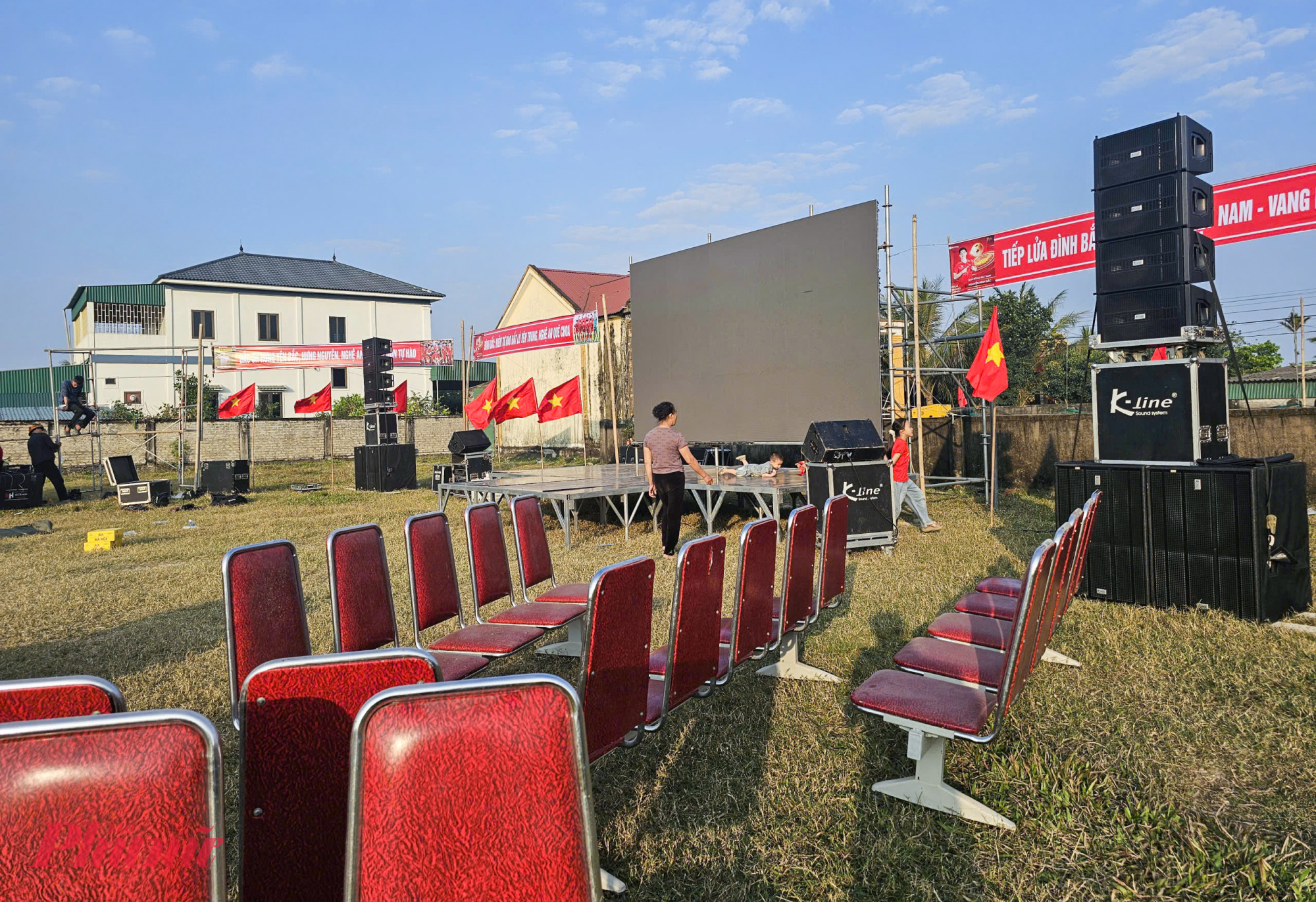 Người dân phân công nhau người treo băng rôn, người lắp loa đài, màn hình led để chuẩn bị cho đêm tiếp lửa U23 Việt Nam