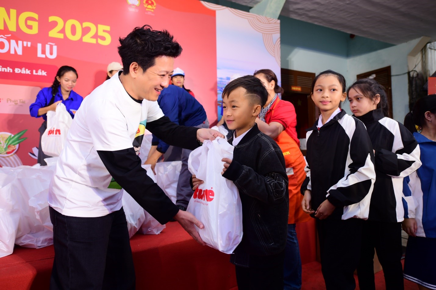 Nghệ sĩ Trường Giang trao quà cho các em nhỏ tại địa phương - Ảnh: ACV, Nguồn: Báo Tuổi Trẻ