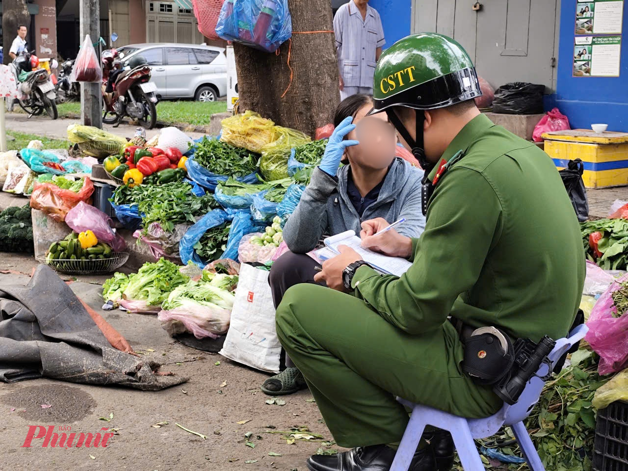 Lực lượng chức năng lập biên bản xử lý người lấn chiếm lòng đường để buôn bán.