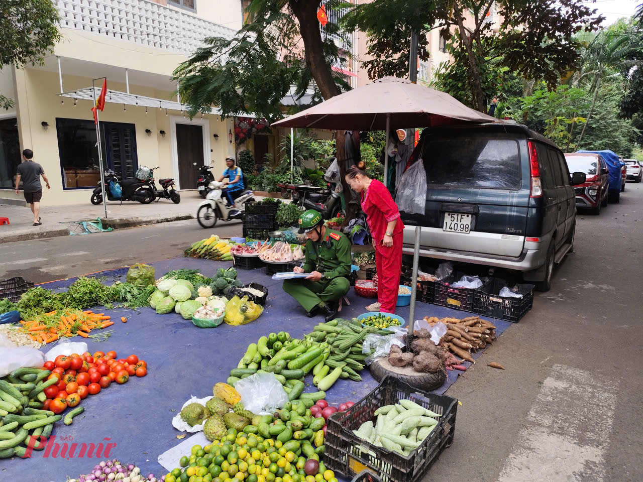 Một tiểu thương bày hàng hóa rau củ chiếm hết phần đường