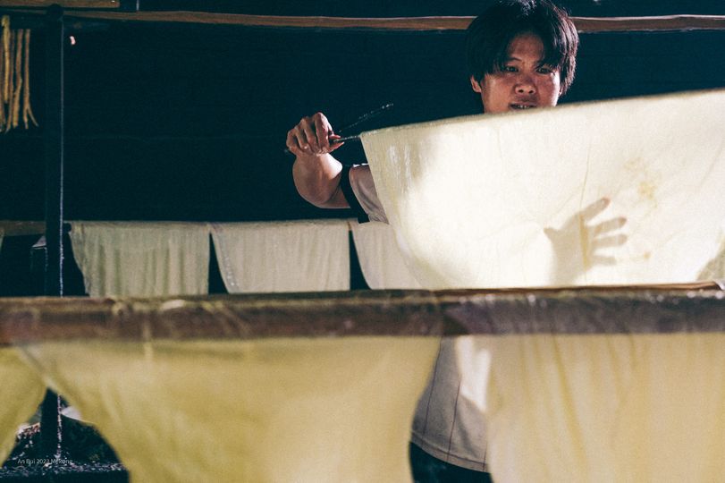 Bạn có thể thử đứng bên bếp lửa, học cách canh nồi sữa đậu, khéo léo vớt từng lớp váng mỏng rồi phơi lên sào tre, cảm nhận rõ sự tỉ mỉ và nhẫn nại mà nghề truyền thống đòi hỏi. Thành quả là những miếng tàu hũ ky còn ấm, thơm mùi đậu nành, được thưởng thức ngay tại chỗ hoặc mua về làm quà - Ảnh: An Bui