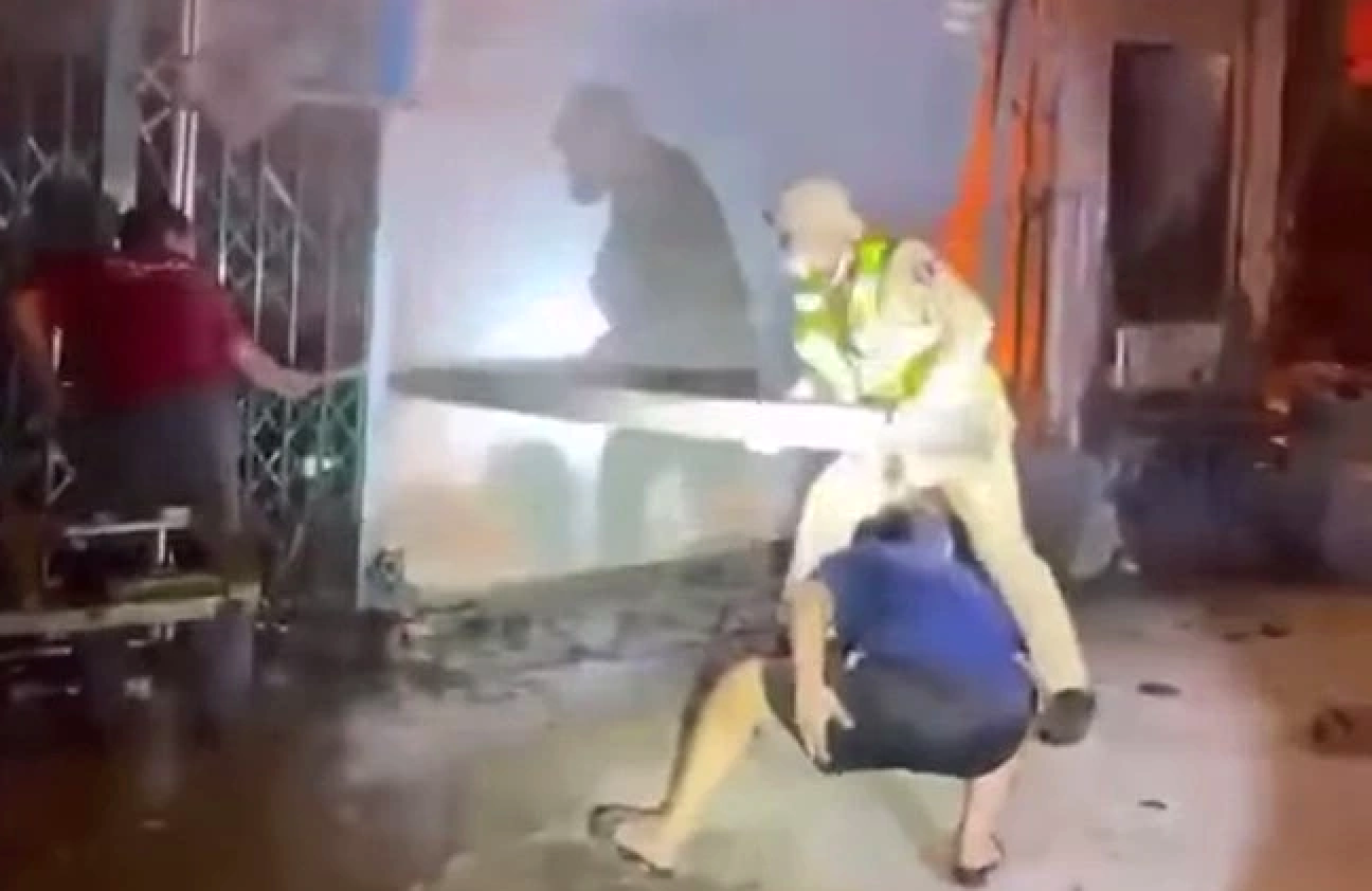 Lực lượng CSGT cùng người dân phá cửa hỗ trợ người dân mắc kẹt bên trong thoát ra khỏi đám cháy - Ảnh: Hoàng Anh