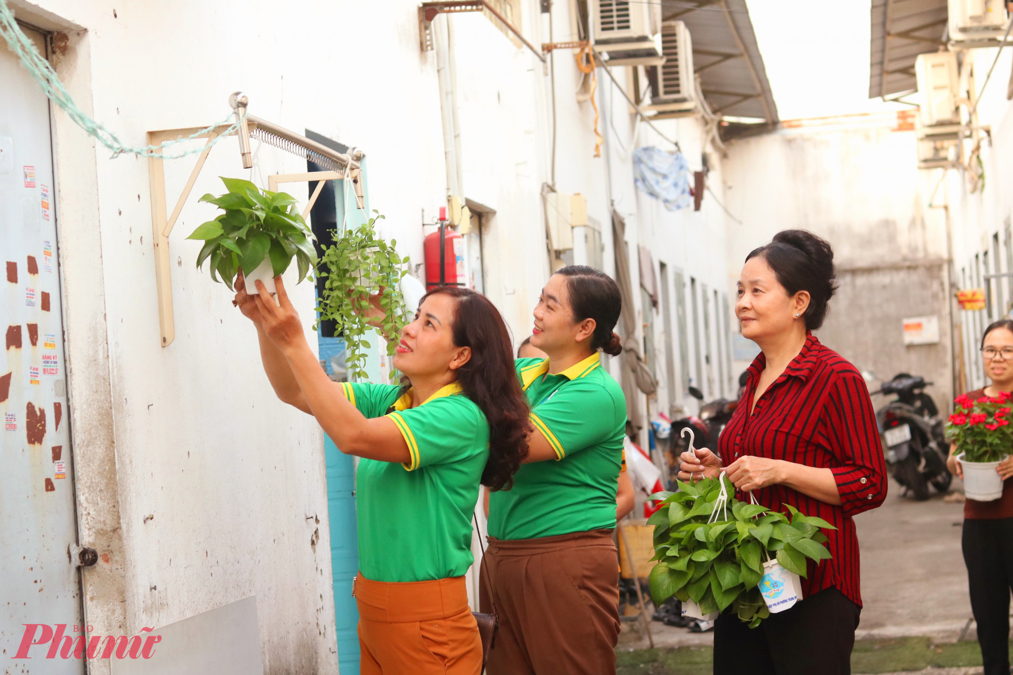 Các chị cán bộ Hội Phụ nữ và người lao động trong khu nhà trọ cùng chung tay tạo mảng xanh từ những chậu cây do Hội LHPN phường tặng - Ảnh: Mẫn Nhi