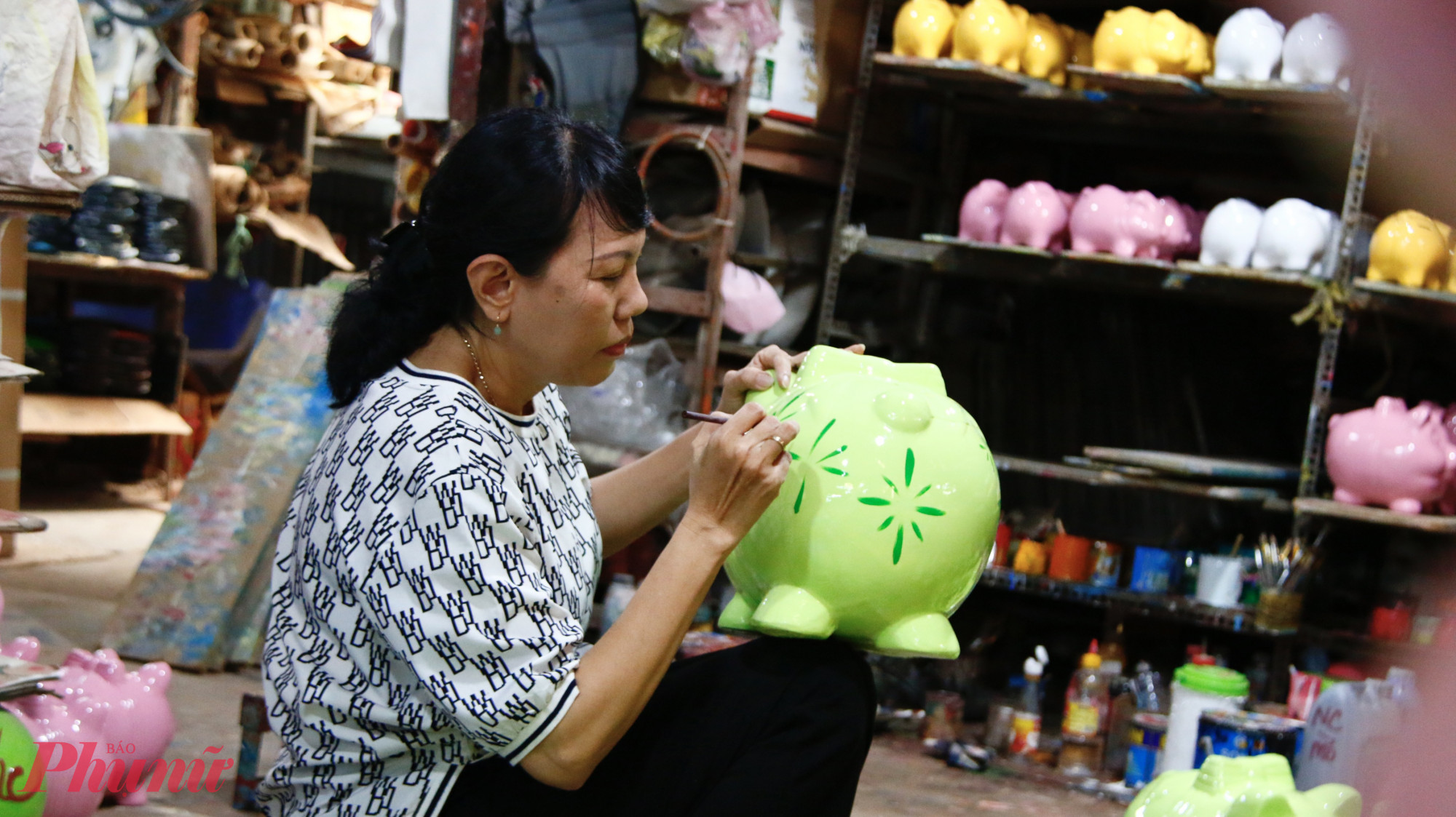 Trong căn xưởng nhỏ rộng khoảng 700 m², bà Nguyễn Thị Thu Hà (54 tuổi), chủ cơ sở sản xuất heo đất – sơn Mài Hà An, tại khu phố Chánh Nghĩa 7, phường Thủ Dầu Một tất bật cùng 8 công nhân chia nhau từng công đoạn sản xuất. Người mài khuôn, sơn màu; người phơi nắng; người tỉ mỉ vẽ hoa văn… Mỗi sản phẩm hoàn thiện đều mang theo sự khéo léo và kinh nghiệm được truyền qua nhiều thế hệ.