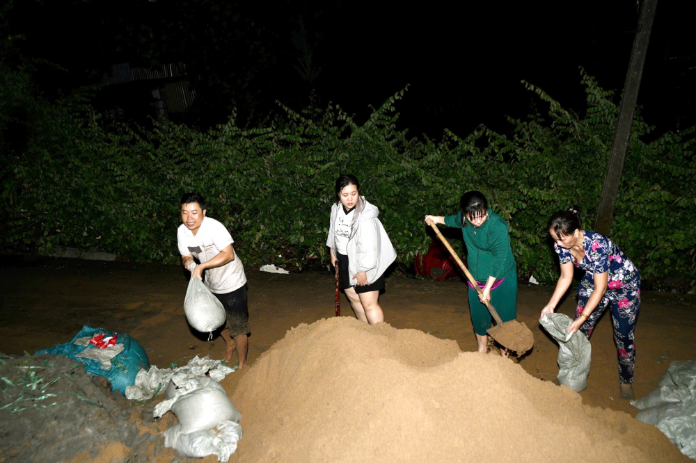 Người dân 2 bên đường Bình Quới đắp bao cát ngăn nước sông tràn vào nhà khi có triều cường - ẢNH: THANH TÂM