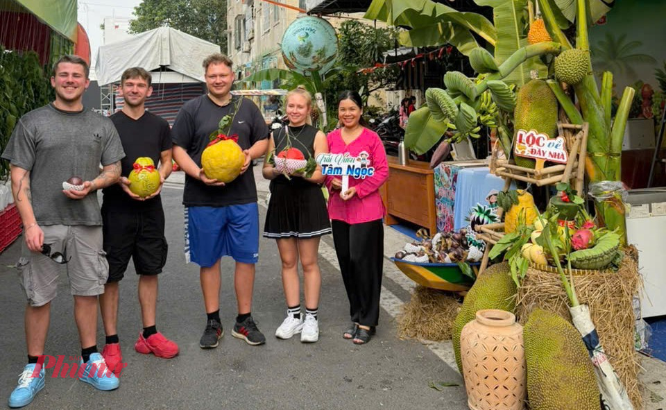 Trái cây chưng Tết tạo hình độc đáo khiến nhiều du khách quốc tế tò mò, dừng lại xem và chụp ảnh tại một phiên chợ tết đang diễn ra ở TPHCM