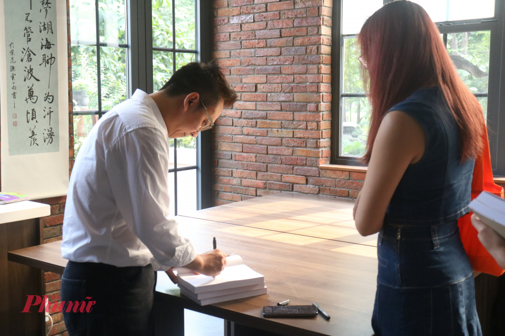 Tác giả Trần Quang Đức ký tặng sách cho độc giả - Ảnh: Phương Nhã