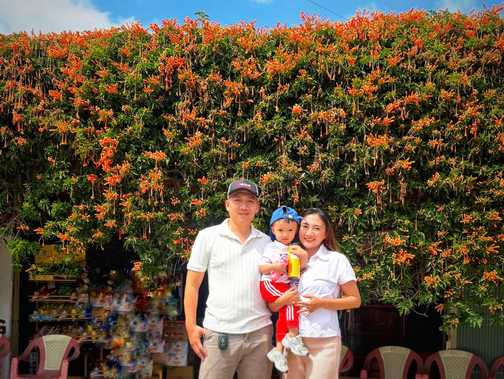 Gia đình du khách rạng rỡ lưu lại khoảnh khắc kỷ niệm trước thềm ngôi nhà phủ đầy sắc cam đặc trưng của vùng đất Lâm Đồng. Dù mỗi ngày đón tiếp cả trăm lượt khách ghé thăm, vợ chồng bà Hà Thị Lánh vẫn duy trì việc mở cửa tham quan hoàn toàn miễn phí với thái độ niềm nở, hiếu khách. Việc điểm đến này nổi như cồn trên các nền tảng mạng xã hội đã góp phần quảng bá tích cực cho hình ảnh du lịch địa phương.