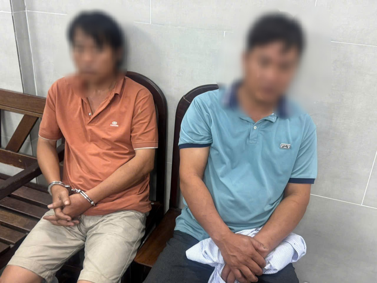 Kẻ trộm (áo cam) và đối tượng tiêu thụ thiên nga trắng - Ảnh: CA