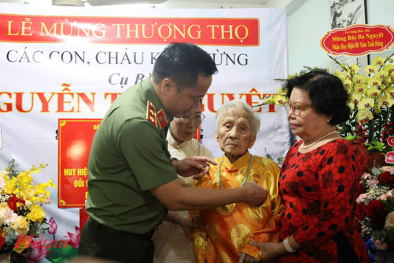 Trung tướng Mai Hoàng trao Huy hiệu 80 năm tuổi Đảng cho bà Nguyễn Thị Nguyệt - Ảnh: Thanh Tâm