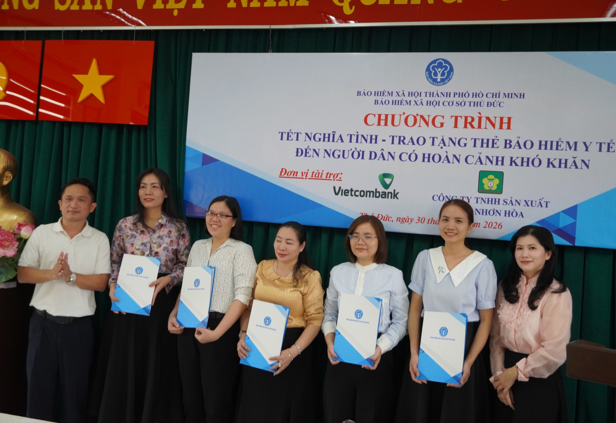 Đại diện BHXH TPHCM (bên phải), nhà tài trợ lên trao thẻ BHYT cho đại diện UBND 5 phường - Ảnh: Thanh Hoa