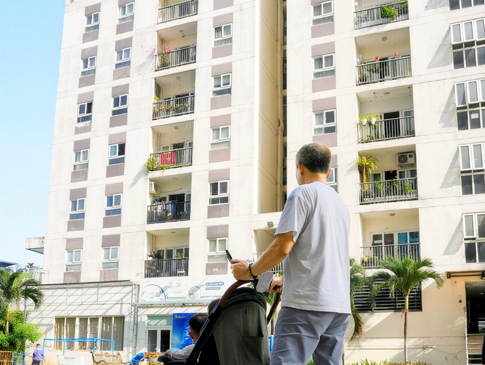 Dưỡng lão tại gia: Khi nhà không chỉ là nơi để ở Một người cao tuổi đi dạo cùng cháu trên sân chung cư ở phường An Khánh, TPHCM - ẢNH: NHÃ CHÂN