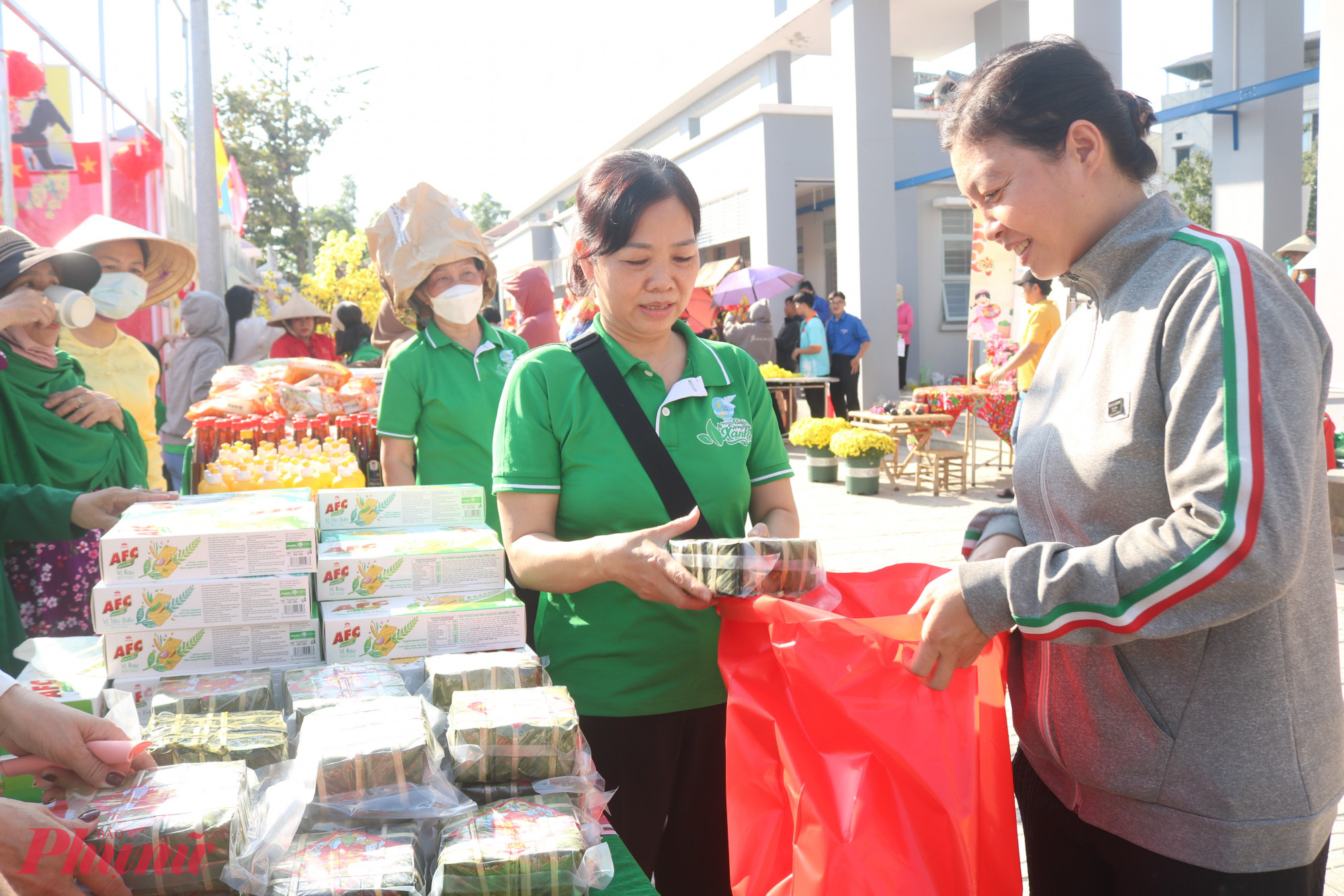 Chị Lê Thị Thanh Thủy (bìa phải) nhận quà từ gian hàng tết xưa của hội - Ảnh: Mẫn Nhi
