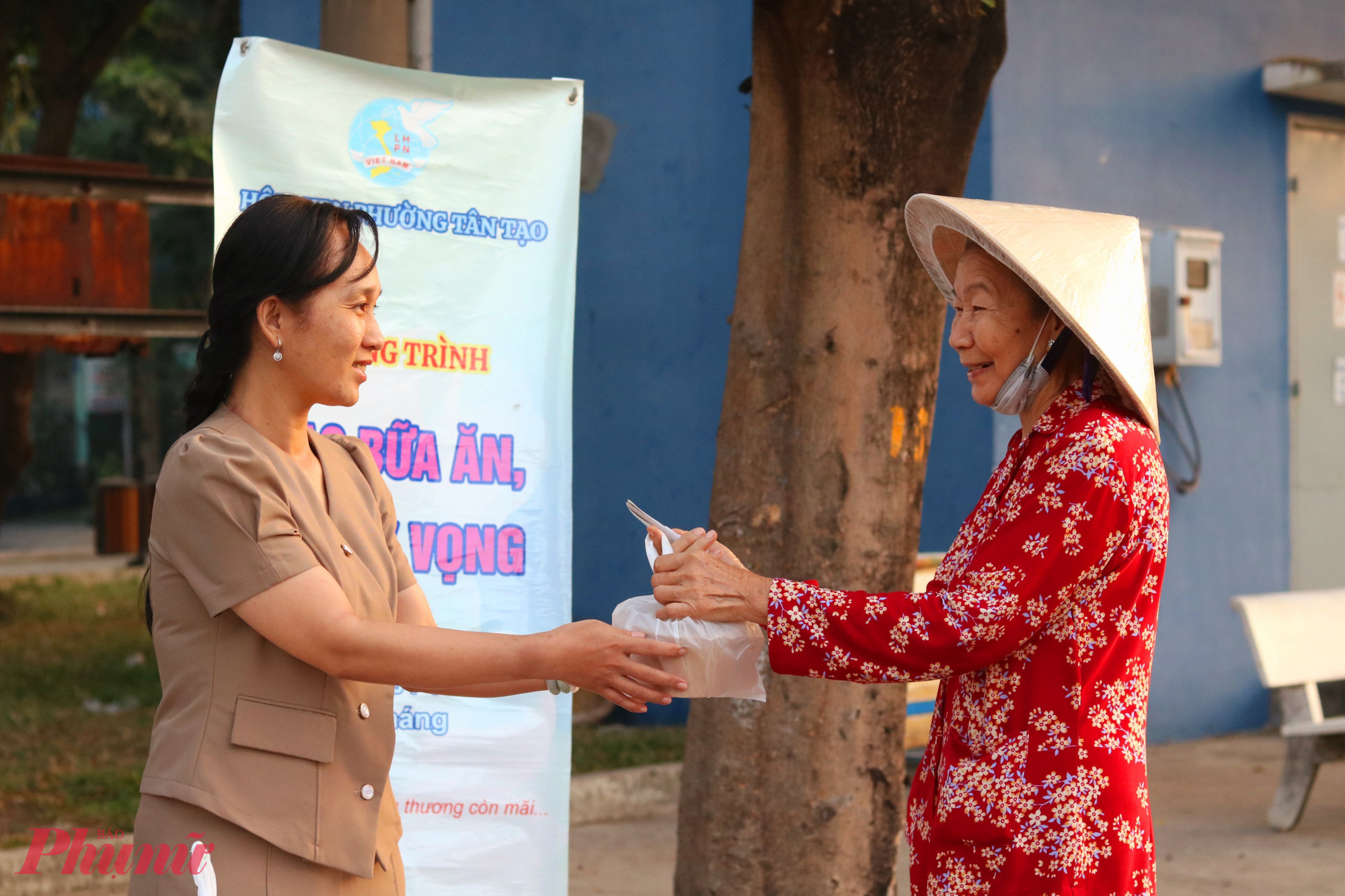 Bà Đinh Thị Hồng Hạnh – Phó chủ tịch Ủy ban MTTQ Việt Nam phường Tân Tạo, Chủ tịch Hội LHPN phường (bìa trái) trao bữa ăn sáng cho người lao động - Ảnh: Mẫn Nhi