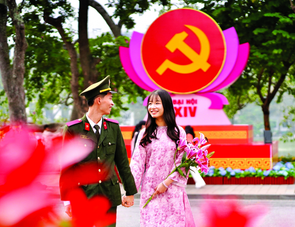 Đôi bạn trẻ ở TP Hà Nội hòa mình trong không khí Đại hội Đại biểu toàn quốc lần thứ XIV của Đảng - ẢNH: BẢO KHANG