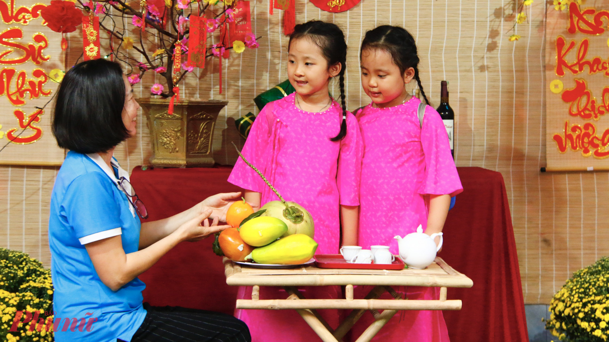 Hội viên phụ nữ còn hướng dẫn các em nhỏ bày trí mâm ngũ quả.