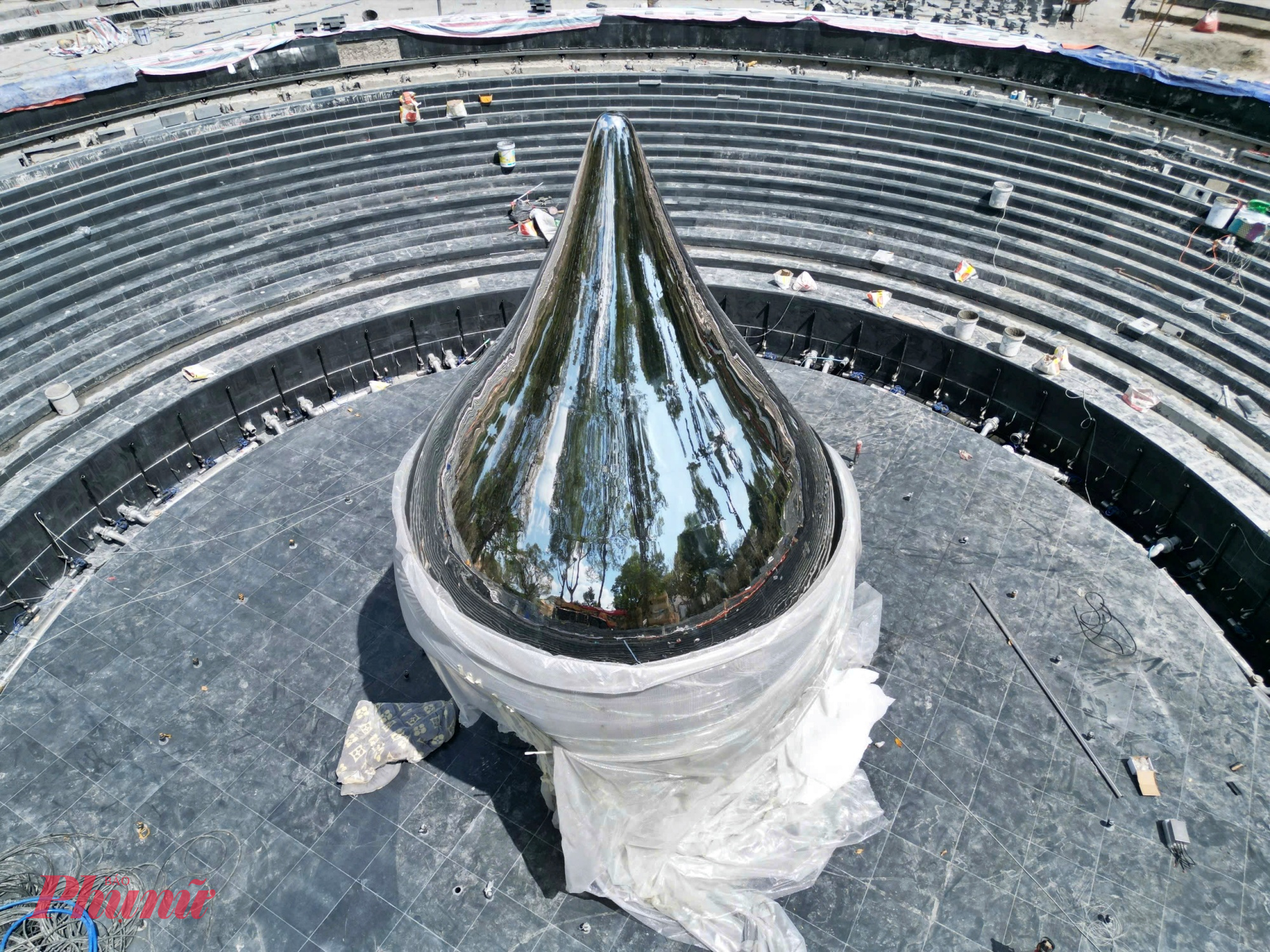 Biểu trưng “Giọt nước mắt” được chế tác từ inox gương có độ bền cao, chống gỉ sét, với bề mặt sáng bóng phản chiếu không gian xung quanh, tạo hiệu ứng thị giác mạnh mẽ khi thay đổi theo ánh sáng và cảnh quan.