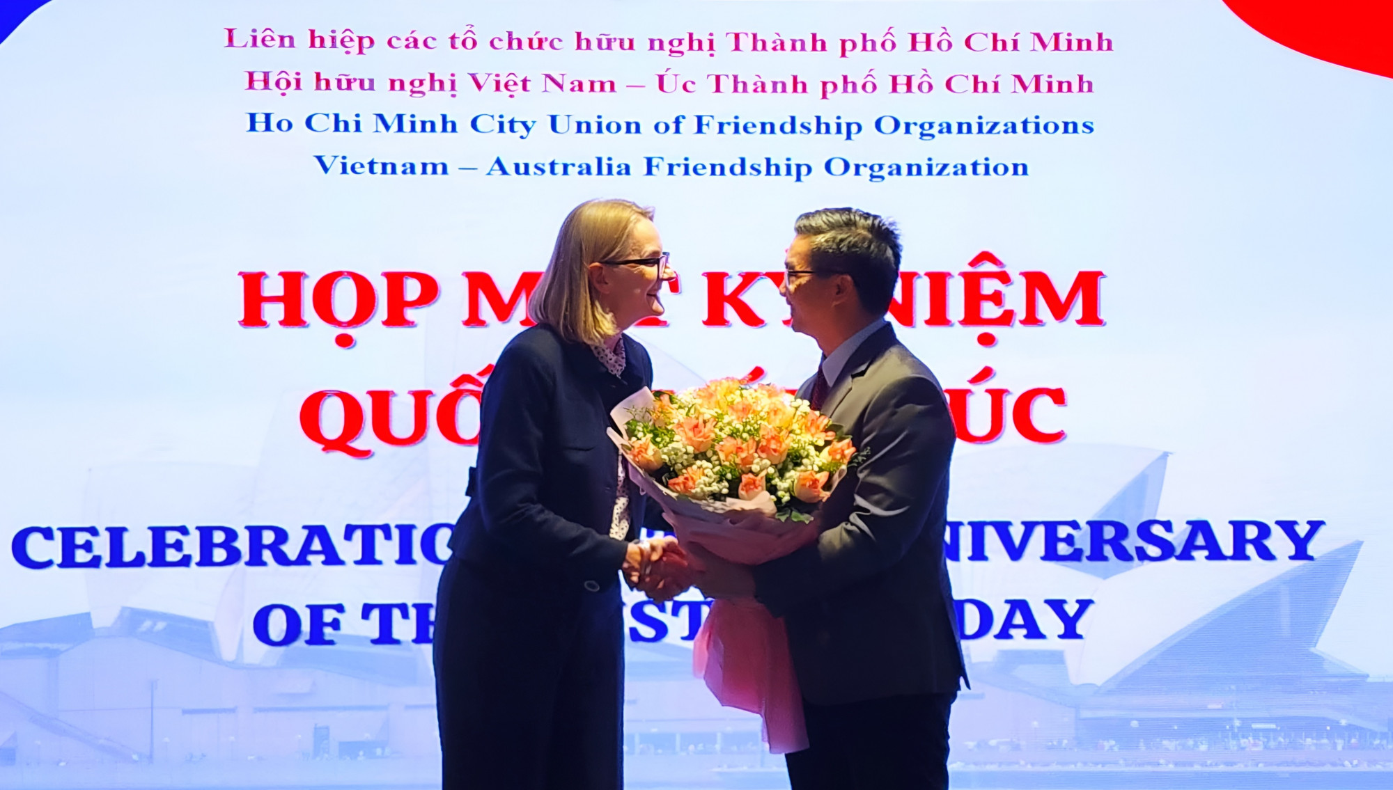 Ông Nguyễn Quang Trung - Phó Chủ tịch hội hữu nghị Việt Nam- Úc TPHCM - gửi tặng bó hoa đến bà Sarah Hooper - Tổng Lãnh sự Úc tại TPHCM 