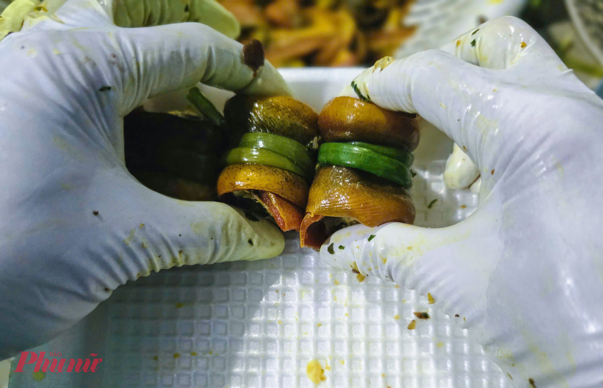 Các cuộn lươn được buộc bằng hành lá, xếp ngay ngắn từ 18-20 viên/khay, sau đó đưa vào tủ cấp đông từ 2-3 tiếng trước khi xuất bán. 