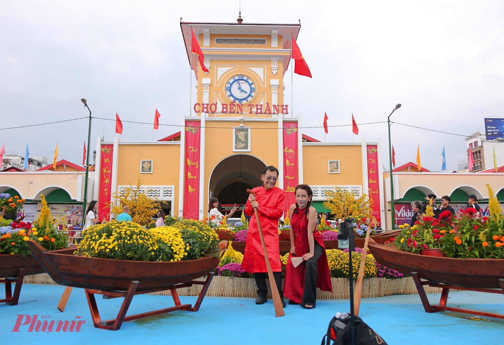 Du khách nước ngoài hào hứng ghi hình, quan sát các tiểu cảnh trang trí Tết, trong khi người dân TP.HCM diện áo dài, trang phục rực rỡ tạo dáng trước ống kính. 