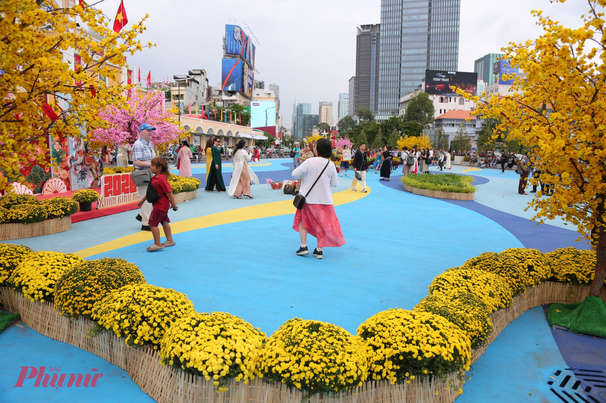 Từng nhóm người thong thả tản bộ, vừa đi vừa trò chuyện, nhiều bạn trẻ và gia đình dừng lại chụp ảnh lưu niệm trước tháp đồng hồ biểu tượng. 