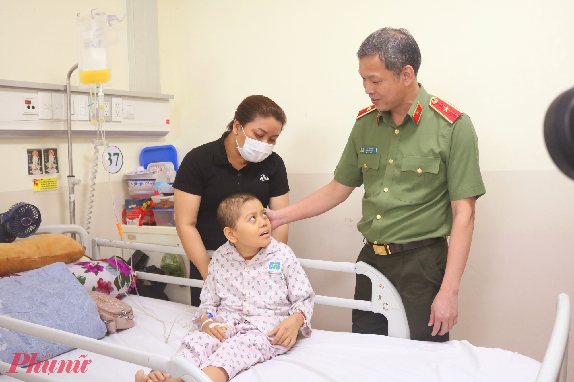 Thiếu tướng Tạ Văn Đẹp – Phó bí thư Đảng ủy, Phó giám đốc Công an TPHCM đến giường bệnh thăm hỏi, động viên và tặng quà cho các bé - Ảnh: Mẫn Nhi