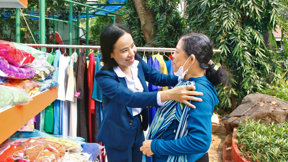 Bà Võ Ngọc Thanh Trúc (bên trái) - Ủy viên Ban Thường vụ Thành ủy, Phó chủ tịch Ủy ban MTTQ Việt Nam TPHCM, Chủ tịch Hội LHPN TPHCM  - giúp hội viên phụ nữ thử áo dài