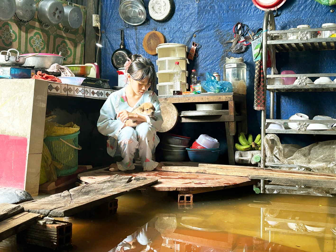 Một bé gái bên chú cún nhỏ trong mùa nước ngập  - Ảnh do nhân vật cung cấp 