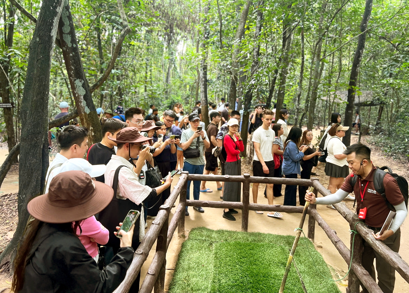 Các hướng dẫn viên của đơn vị lữ hành, dịch vụ du lịch tại TPHCM đang thuyết minh về địa đạo Củ Chi với khách quốc tế