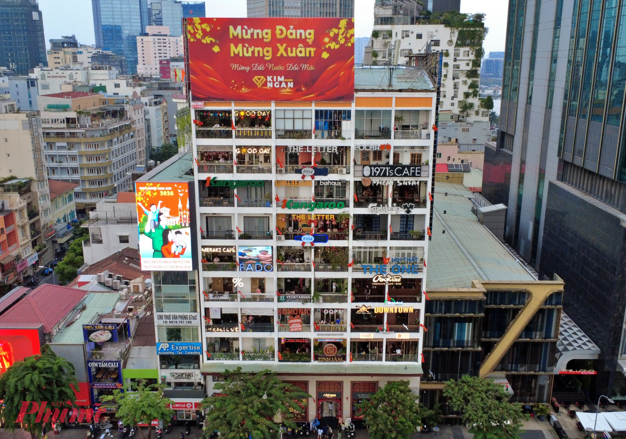 Sau chỉnh trang, mặt tiền được làm sạch, ánh sáng được bố trí tiết chế, không phá vỡ sinh hoạt bên trong. Những ô ban công vẫn đó, nhưng tổng thể công trình nay hài hòa hơn với không gian phố Nguyễn Huệ những ngày giáp Tết.