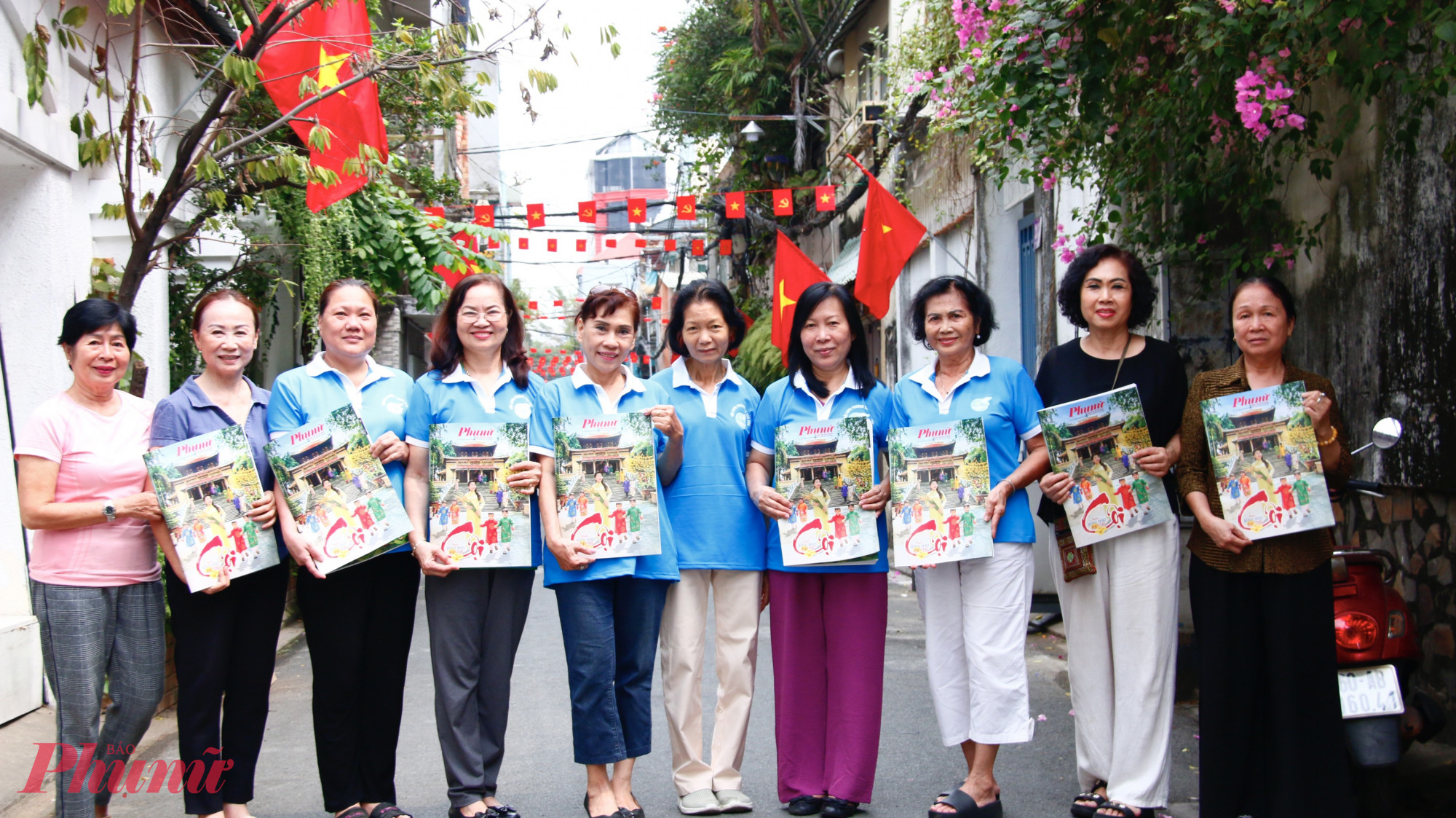 Cán bộ, hội viên phụ nữ khu phố 9, phường Tân Sơn Hoà chụp ảnh lưu niệm cùng báo báo xuân Báo Phụ nữ TPHCM.