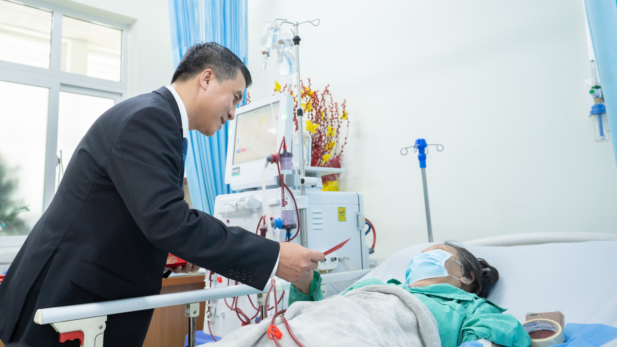 Bác sĩ  Phạm Thanh Việt đến giường bệnh lì xì cho bệnh nhân đang chạy thận