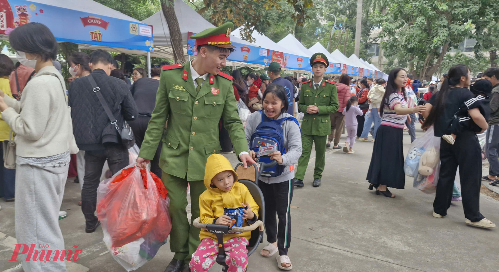 Hình ảnh đẹp của cán bộ, chiến sĩ công an đảm bảo an ninh, trật tự tại Phiên chợ 0 đồng khi tận tình hỗ trợ gia đình bệnh nhi đi nhận quà.