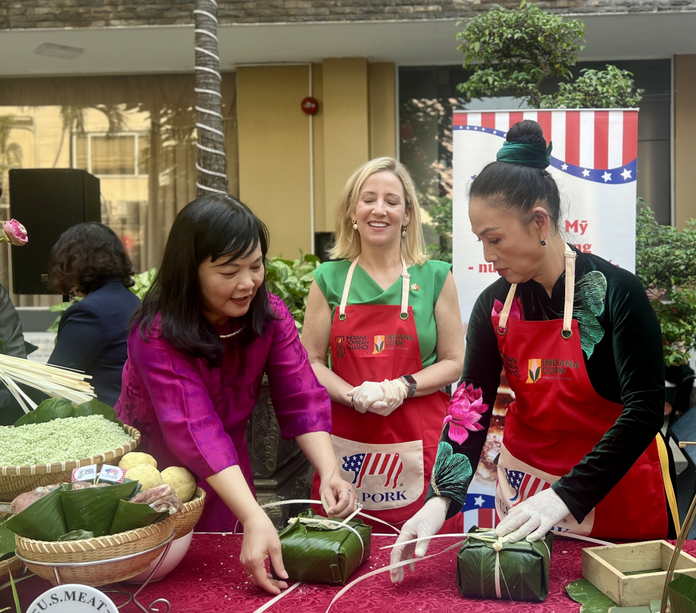 Cô Võ Thị Mỹ Vân (bìa trái) hướng dẫn cho đại diện cơ quan ngoại giao Mỹ gói bánh trưng, trong khuôn khổ Hội thi gói bánh Tết, một hoạt động thường niên của trường của trường năm 2026. Ảnh: Quốc Thái