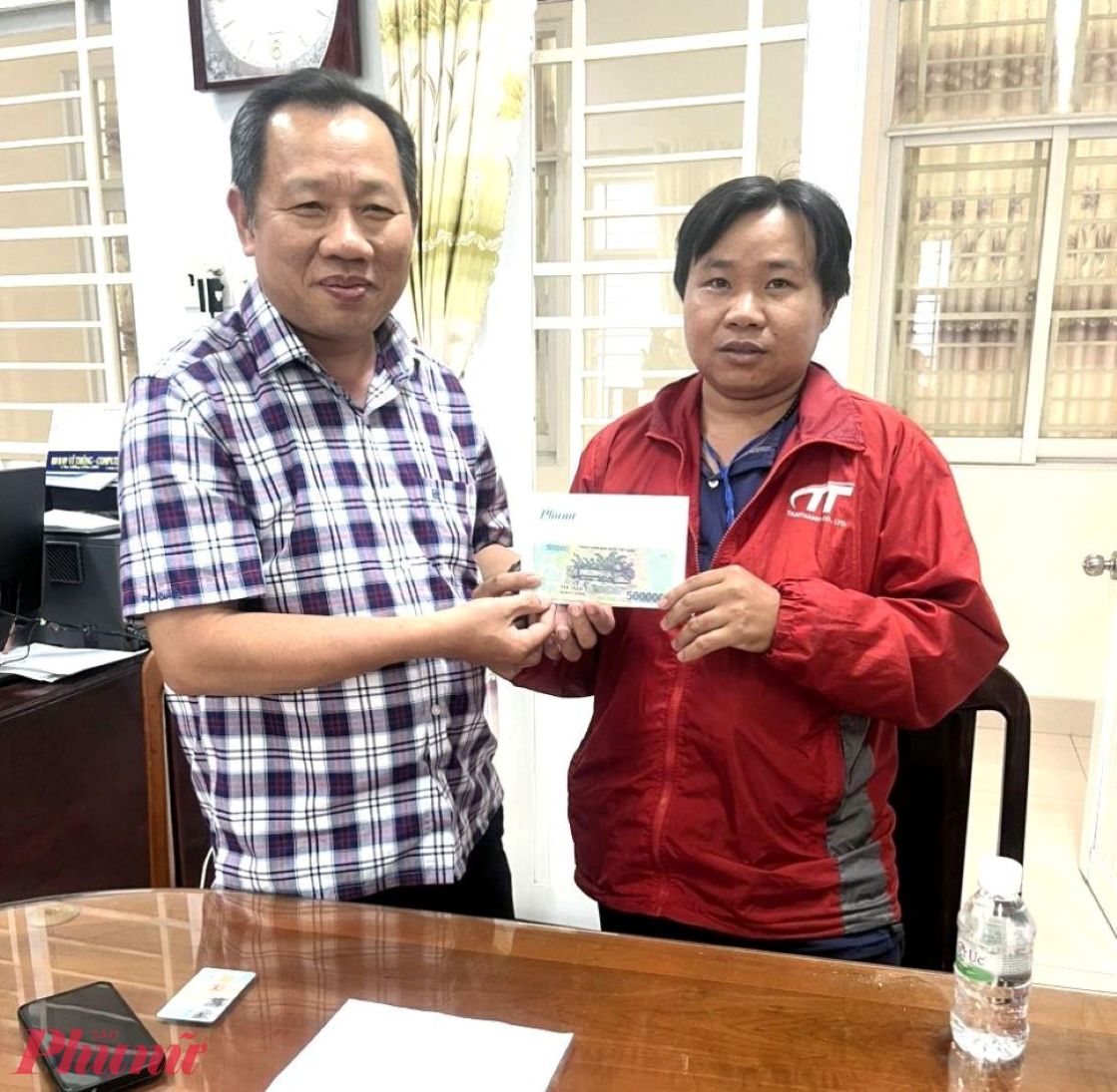 Nhà báo Huỳnh Lợi - Trưởng VPĐD Vùng miền, Báo Phụ Nữ TPHCM (bên trái) trao tiền do bạn đọc hỗ trợ bé Khang (xã Cái Nhum, tỉnh Vĩnh Long) điều trị bệnh. Ảnh: Huỳnh Trọng