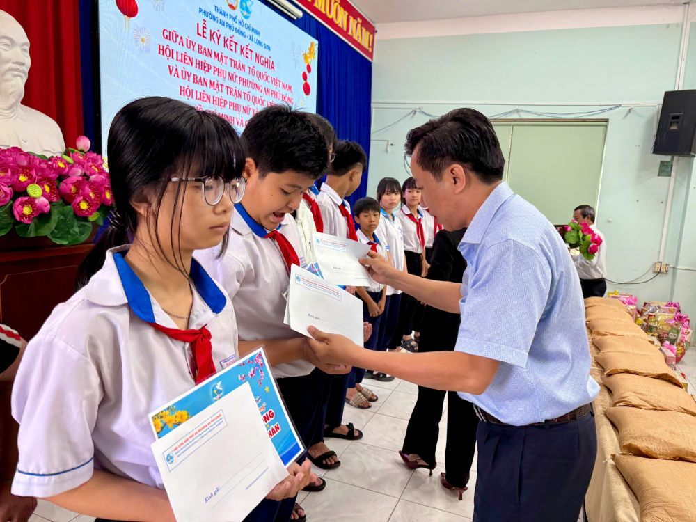 Ông Nguyễn Chí Thiện - Ủy viên Ban thường vụ Đảng ủy, quyền Chủ tịch UBND phường An Phú Đông trao học bổng cho các em học sinh xã Long Sơn - Ảnh: Hội LHPN phường An Phú Đông  
