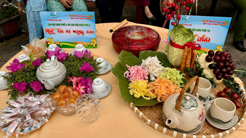  Mỗi bàn mứt được các chị chuẩn bị công phu, chu đáo; màu sắc rực rỡ, hài hòa, kết hợp cùng hoa và trà, tạo nên không gian Tết thêm ấm áp, rộn ràng - Ảnh: TP