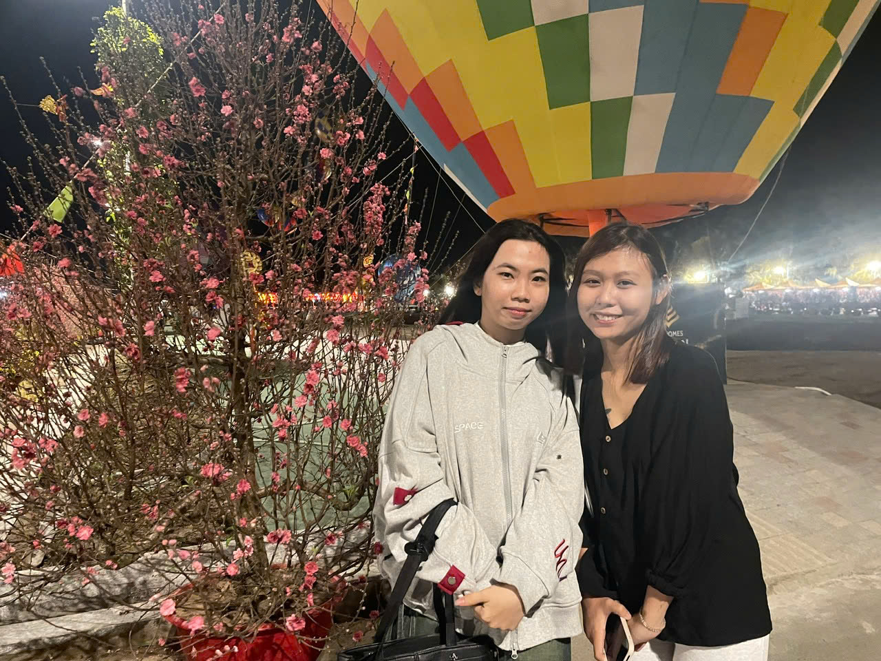 Quỳnh Như (áo đen) và Hồ Thị Tiên check-in bên khinh khí cầu khổng lồ và vườn đào