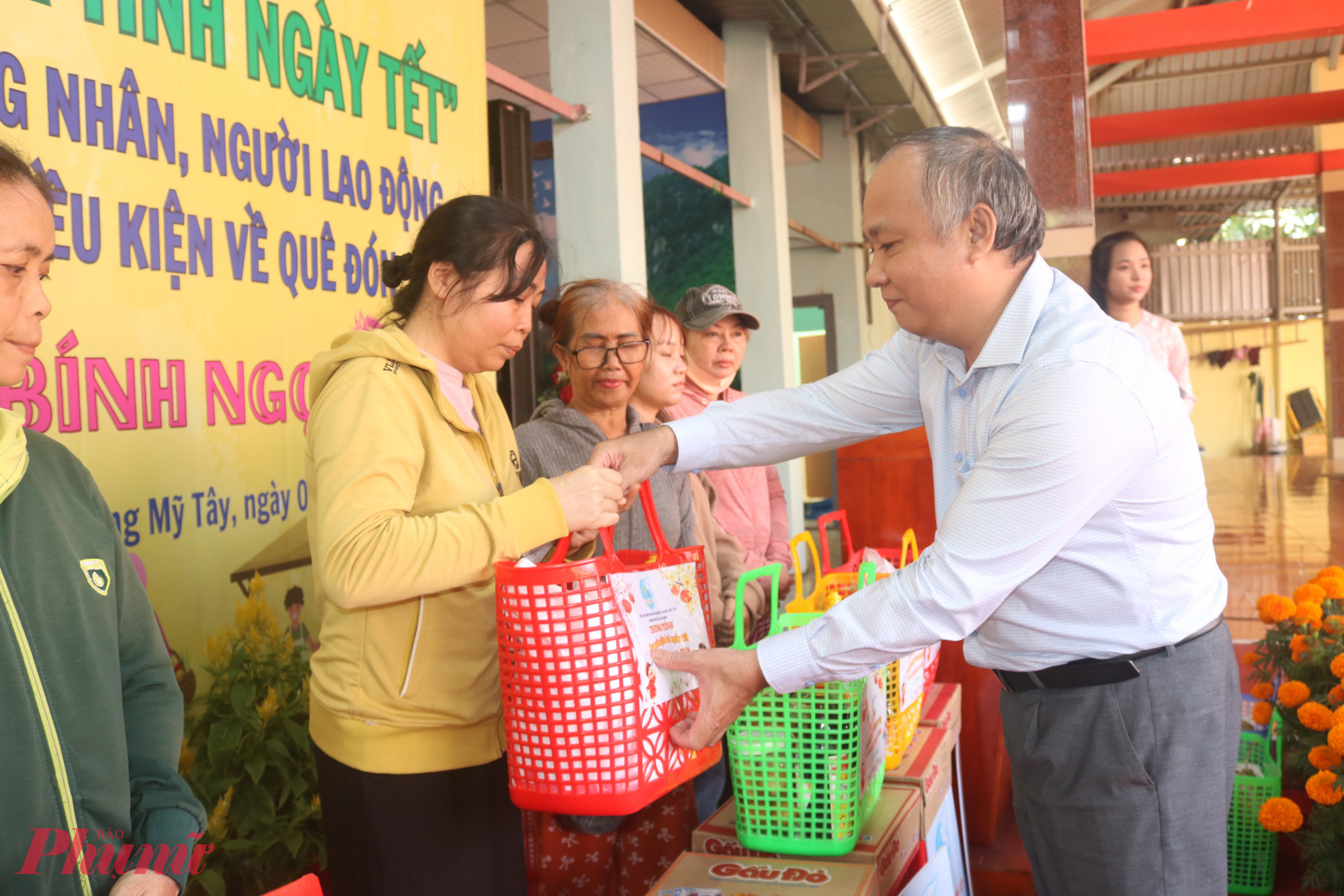 Ông Lê Văn Cường – Phó bí thư thường trực Đảng ủy phường Trung Mỹ Tây – trao quà từ “Chợ quê nghĩa tình ngày tết” cho các bà, các chị - Ảnh: Thảo Nguyên