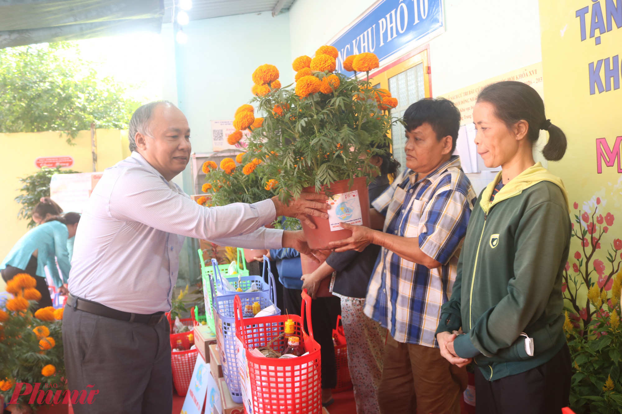 Hoa tết được trao đến tay đại diện các hộ gia đình - Ảnh: Thảo Nguyên