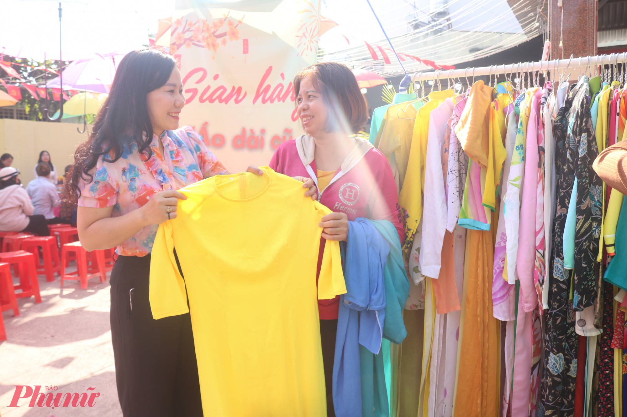 Bà Đặng Thị Kim Thoa – Phó chủ tịch Ủy ban  MTTQ Việt Nam Phường Trung Mỹ Tây, Chủ tịch Hội LHPN phường (bìa trái) – giúp chị em lựa chọn bộ áo dài phù hợp nhất với bản thân - Ảnh: Thảo Nguyên