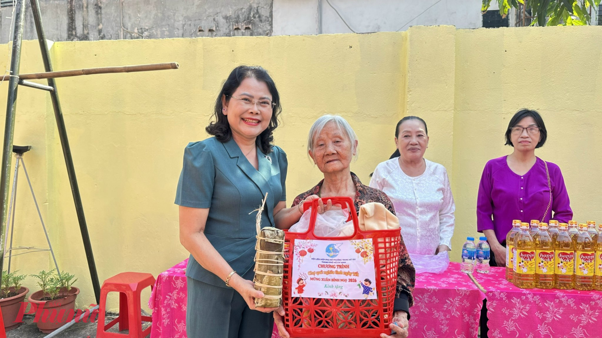 Bà Nguyễn Thị Ngọc Duyên – Bí thư Đảng ủy, Chủ tịch HĐND phường Trung Mỹ Tây (bìa trái)– trao quà từ “Chợ quê nghĩa tình ngày tết” đại diện các hộ dân - Ảnh: Như Ý 