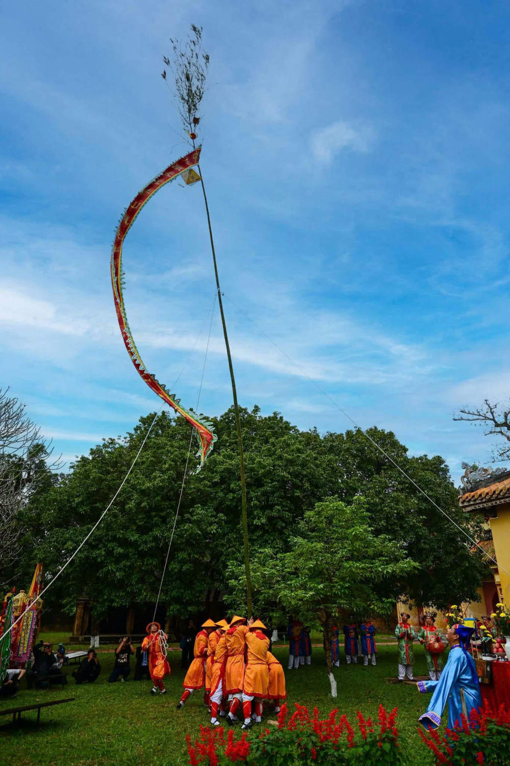 Cây nêu trong cung đình Huế không đơn thuần là một thân tre cao, mà là một biểu tượng được lựa chọn kỹ lưỡng. Tre dùng làm nêu phải là tre thẳng, cao, chắc, thể hiện sự chính trực và bền bỉ. Trên ngọn nêu thường treo các vật mang ý nghĩa trấn trạch và cầu phúc như lá bùa, khánh đất, chuông nhỏ, hoặc những dải lụa. Khi gió xuân thổi qua, tiếng leng keng vang lên như lời nhắc nhở đất trời đã sang thời khắc mới, mọi điều xui rủi phải lui bước.