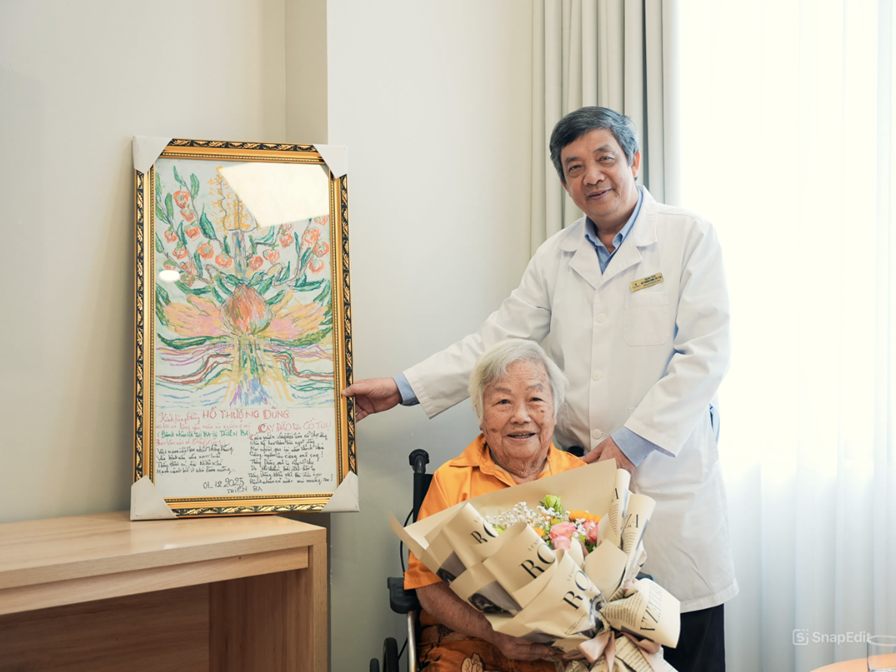 Cụ Ba tự tay trao tặng PGS.TS.BS Hồ Thượng Dũng bức tranh cùng những vần thơ tri ân trong lần tái khám - Ảnh: Vinmec