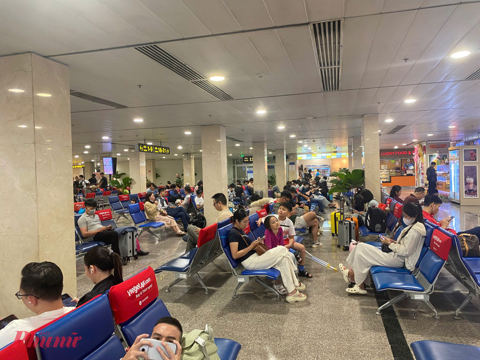 Nhiều hành khách tranh thủ dùng điện thoại giải trí chờ đến giờ lên máy bay.