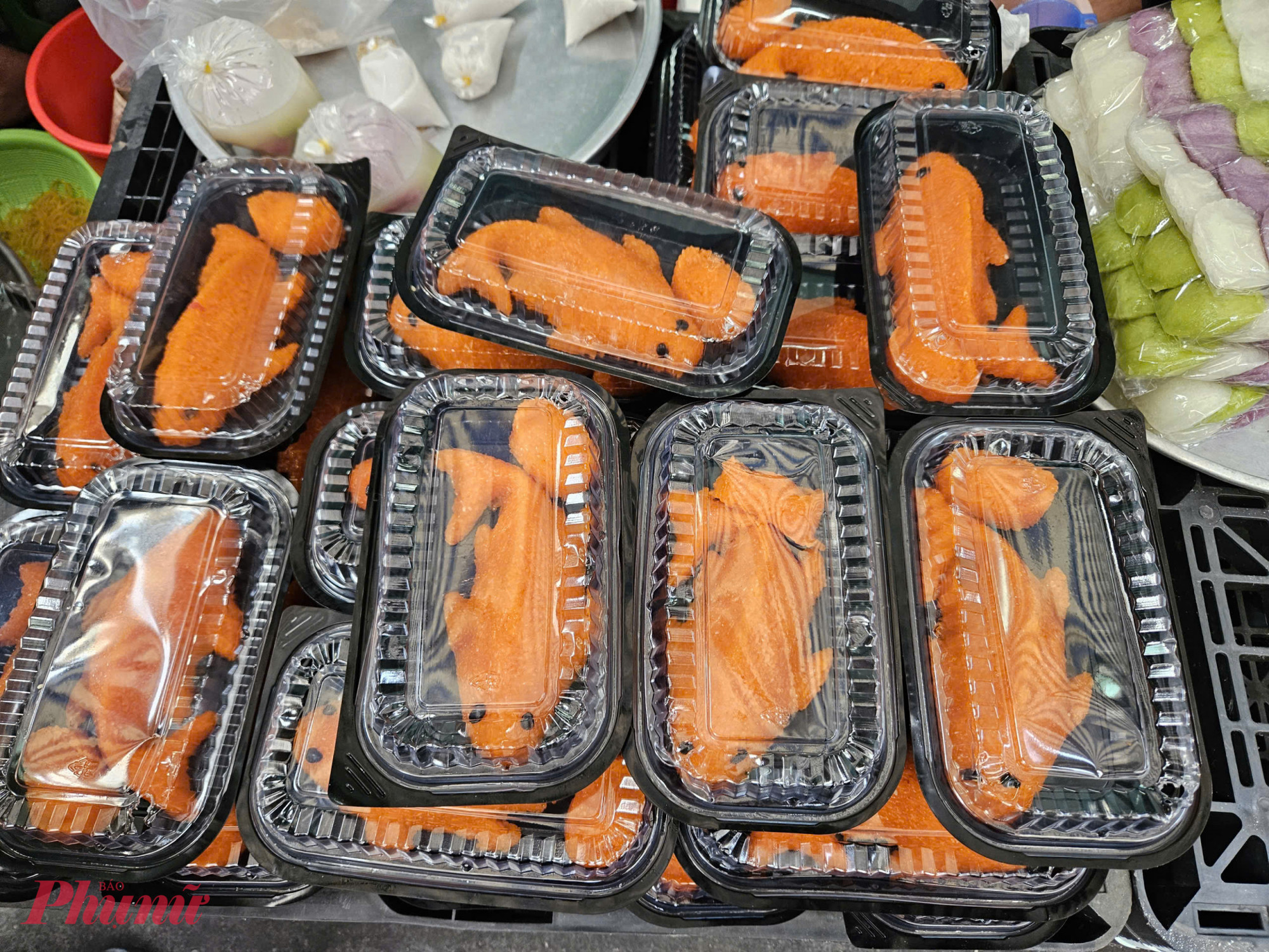 Xôi gấc tạo hình cá chép, đóng hộp sẵn để phục vụ mâm cúng ông Công ông Táo. Mỗi hộp xôi có giá từ 30.000 - 50.000 đồng, tùy điểm bán. 