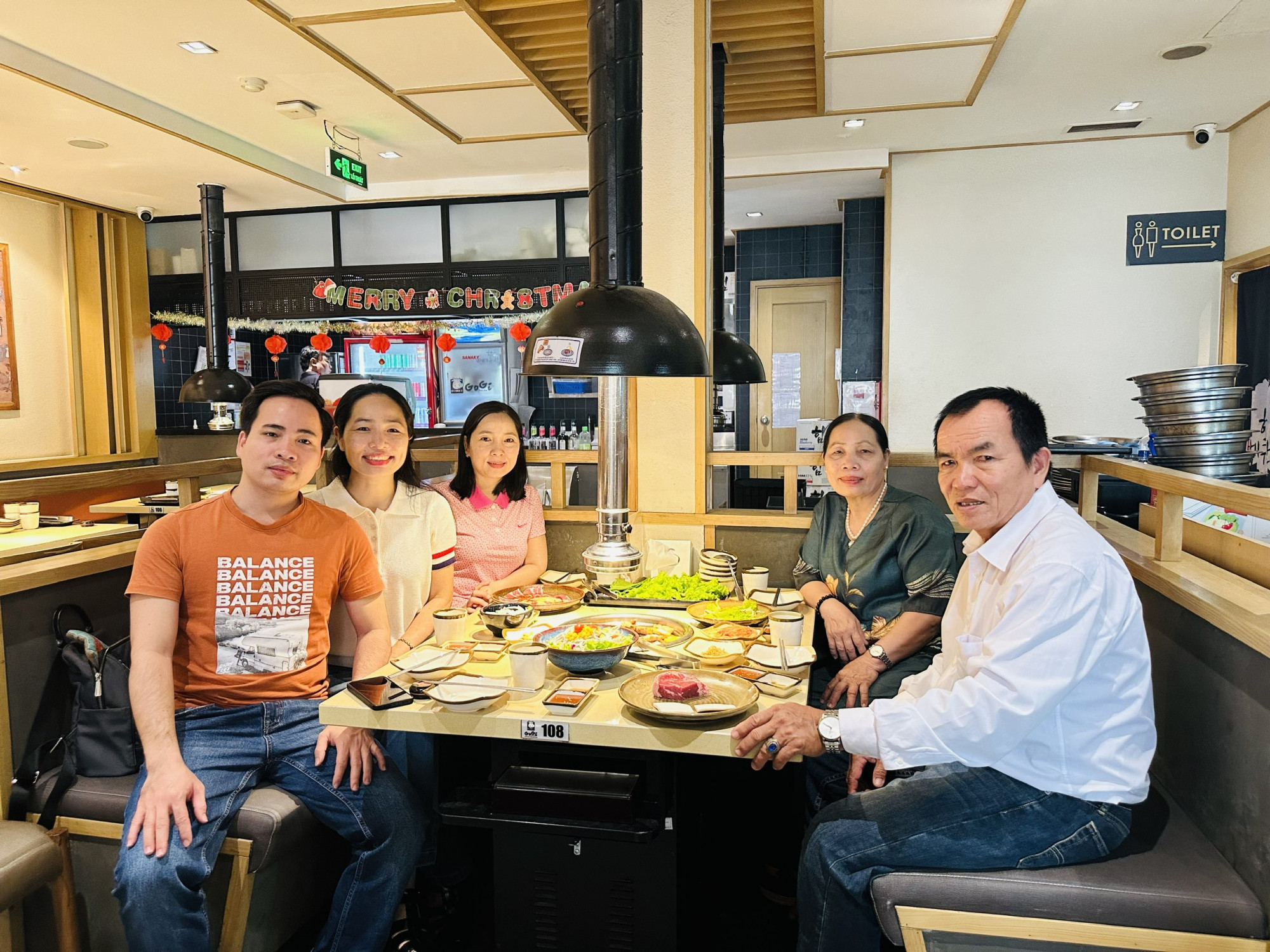 Cả nhà cùng nhau thưởng thức món thịt nướng yêu thích trong không gian ấm cúng ngày cuối năm