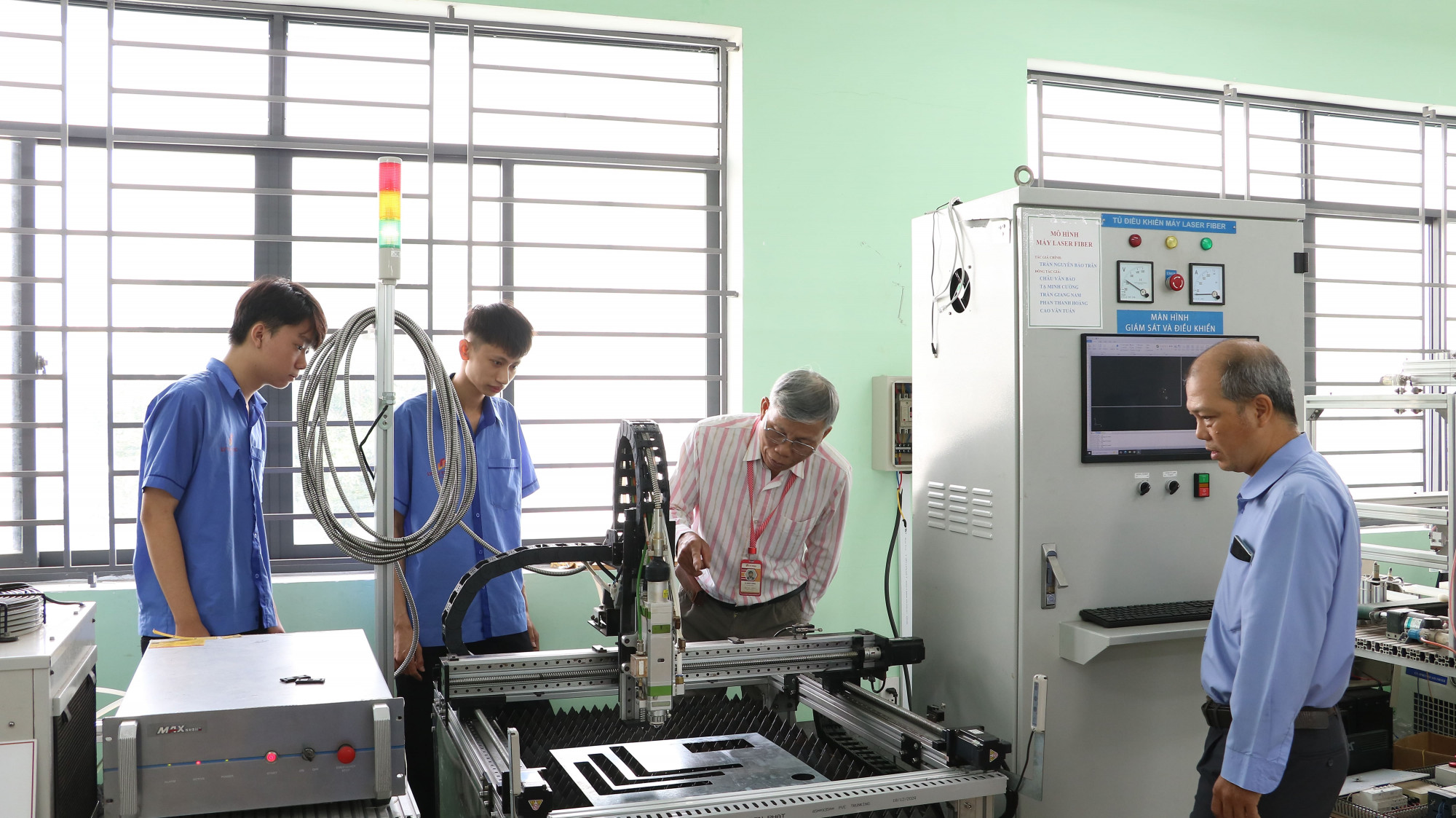 Thầy trò Trường cao đẳng Lý Tự Trọng bên mô hình thiết bị do thầy cô tạo ra để sinh viên thực tập - Ảnh: Trang Thư